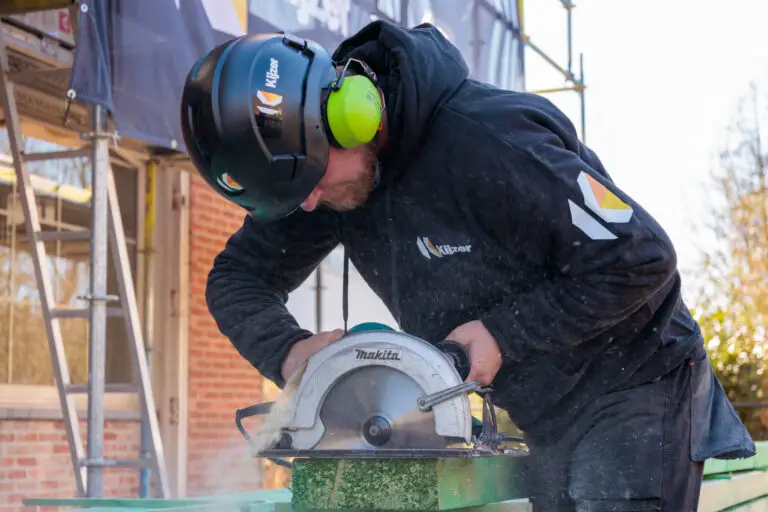 Projectrapportage: Werknemer zaagt op dak, toont actie en vakmanschap, door Toméci vastgelegd.
