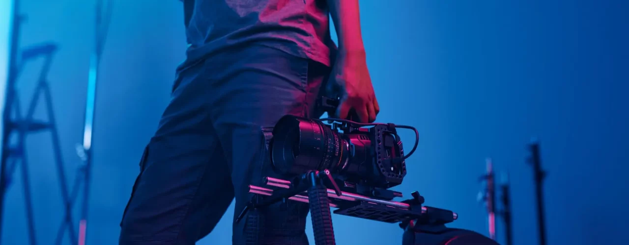 Professionele fotograaf met camera rig in een studio met blauw licht, illustreert Toméci Fotografie diensten.